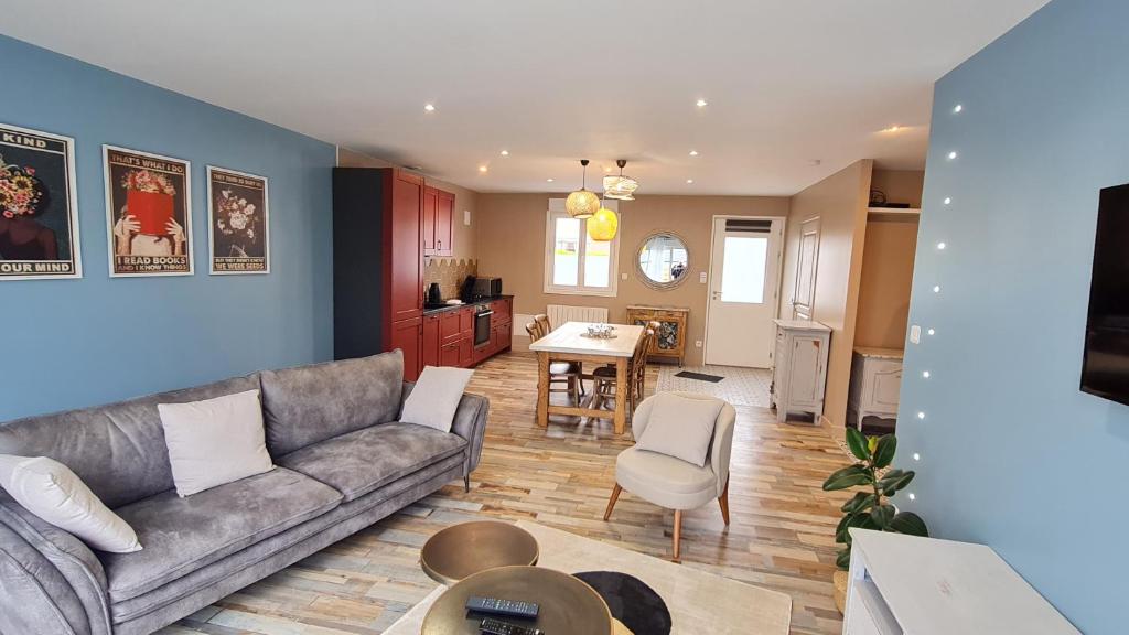 a living room with a couch and a table at Ô de Vents - à 30m de la plage in Sangatte