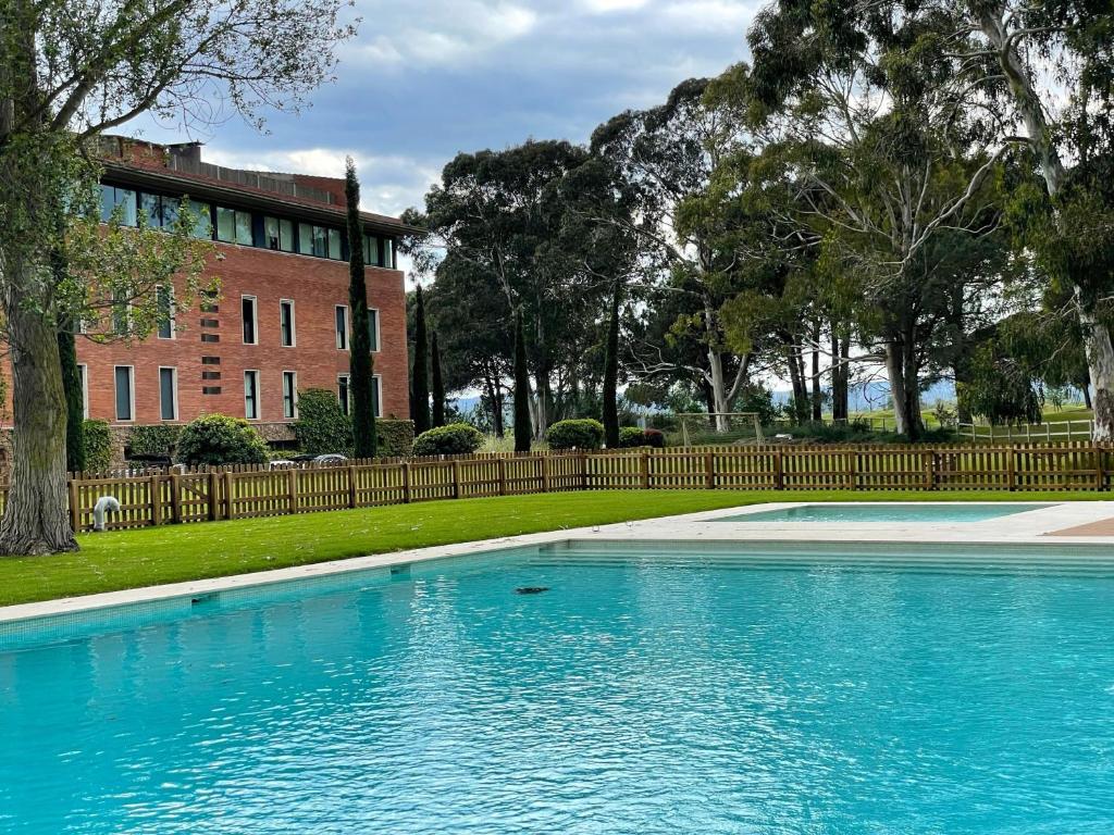 a swimming pool in front of a brick building at EMPORDÀ GOLF 4 1-2 in Gualta