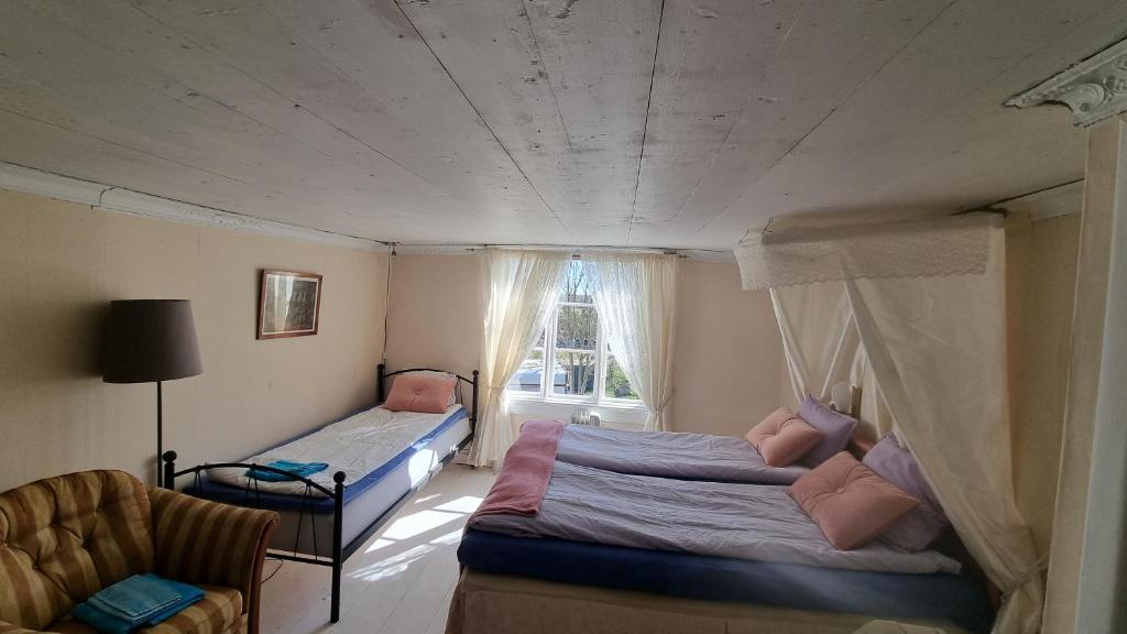1 dormitorio con 2 camas y ventana en Paradiset, en Hammarland