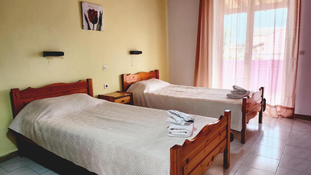 a hotel room with two beds and a window at VILLA ELENA in Ipsos