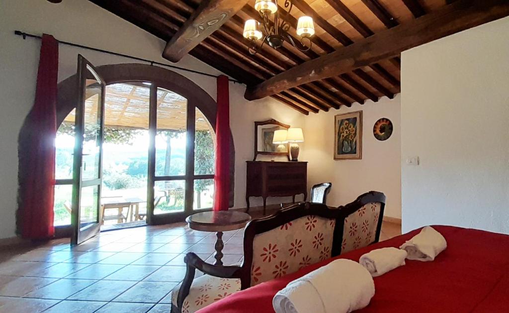 1 dormitorio con cama roja y puerta abierta en Borgo de' Muracci, en Ribolla
