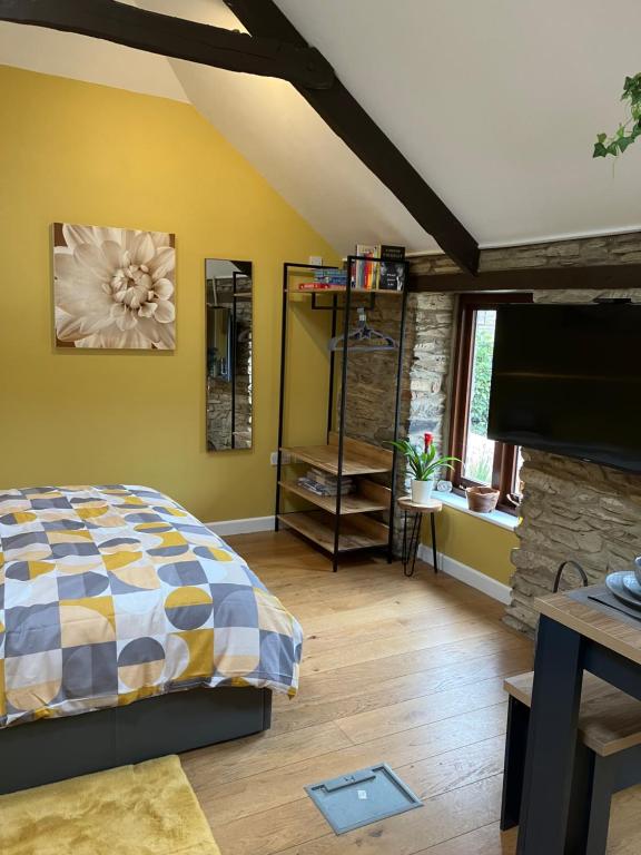 1 dormitorio con 1 cama y chimenea de piedra en The parlour en Bodmin