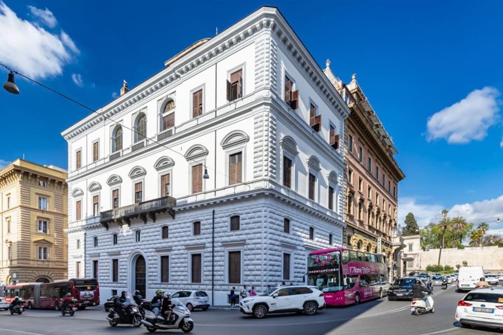 a large white building on a city street with cars at Stradivari Suite Roma in Rome