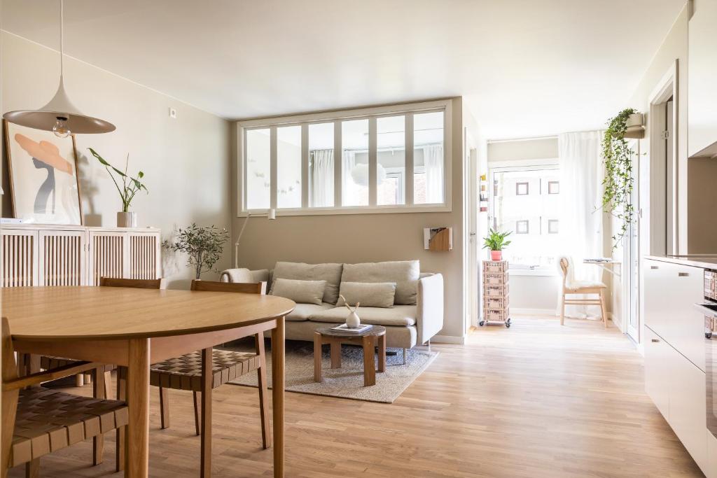 a living room with a table and a couch at Scandinavian apartment with 2 bedrooms and terrasse - close to Storo Storsenter and all public transport in Oslo