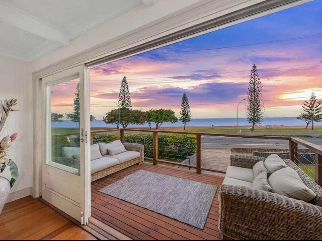 a living room with a view of the ocean at Bells Beach Bungalow in Clontarf