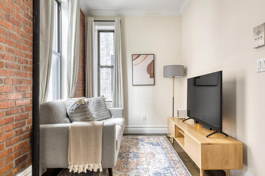 a living room with a couch and a tv at Nolita 1br w wd nr New Museum NYC-1037 in New York