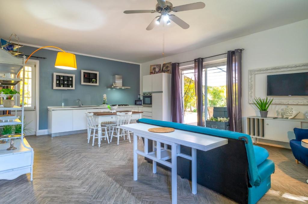 cocina y sala de estar con mesa y sillas en Guest House Abbacurrente, en Platamona