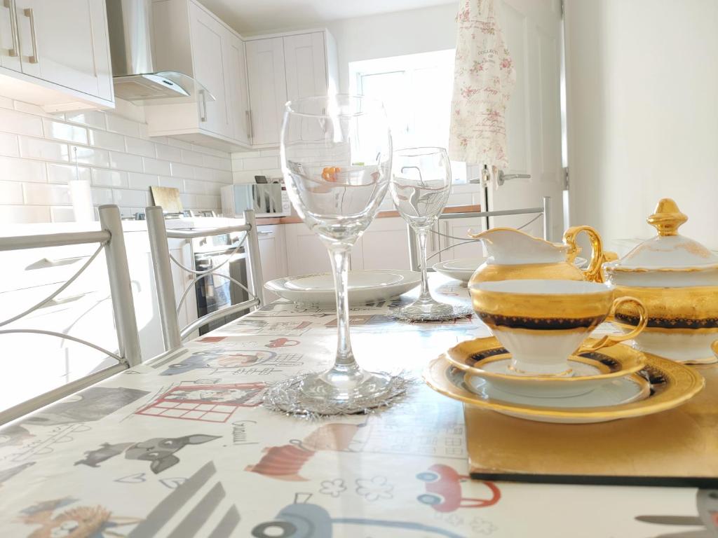 a table with glasses and plates on a kitchen counter at Cosy Family Home in Long Eaton, Nottingham in Nottingham