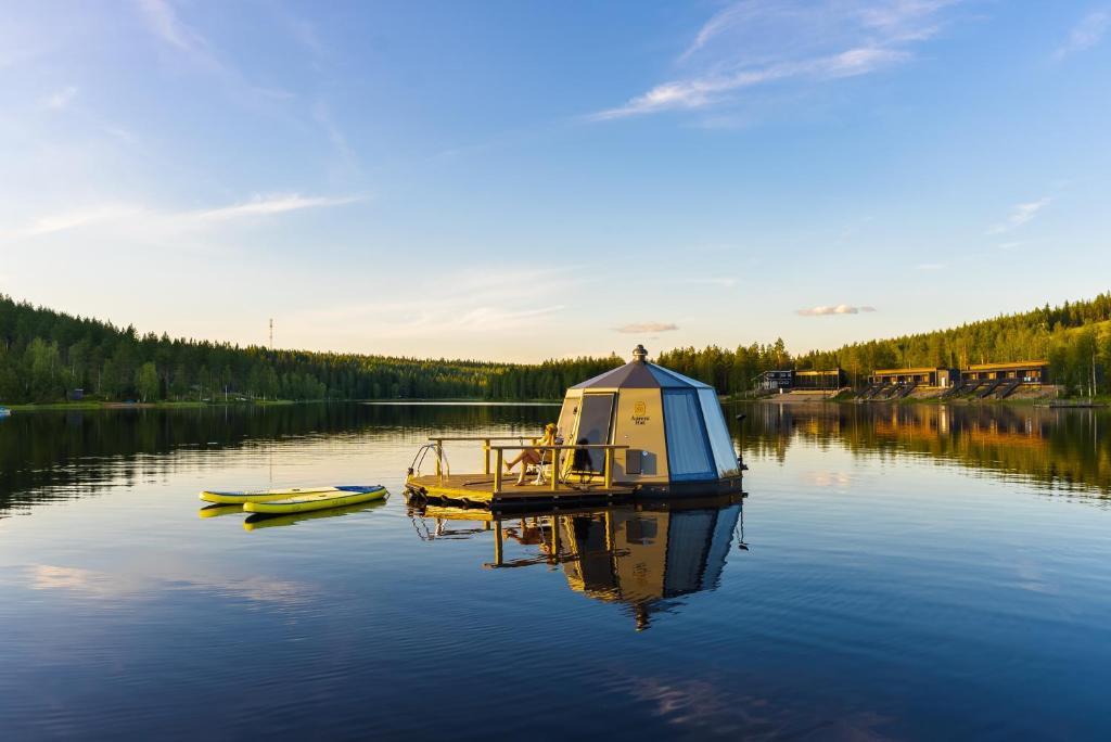 a boat sitting on a lake with a dome on it at Lake Igloo Ukkohalla in Hyrynsalmi