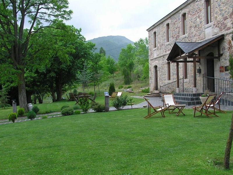 a yard with chairs and a stone building at Días de Luna in Sena de Luna