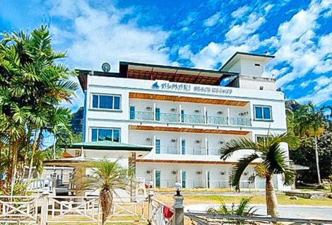 um grande edifício branco com palmeiras em frente em RedDoorz @ Almari Beach Resort Tawi-Tawi 