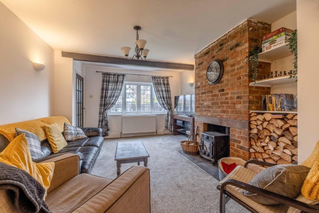 a living room with a couch and a brick wall at COSY HOME NEAR DORNEY, WINDSOR & Free Parking in Taplow