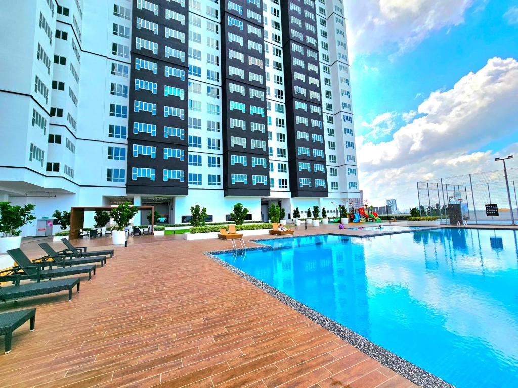 un grande edificio con piscina di fronte a un edificio di Amber Cove Executive Suites Melaka a Malacca