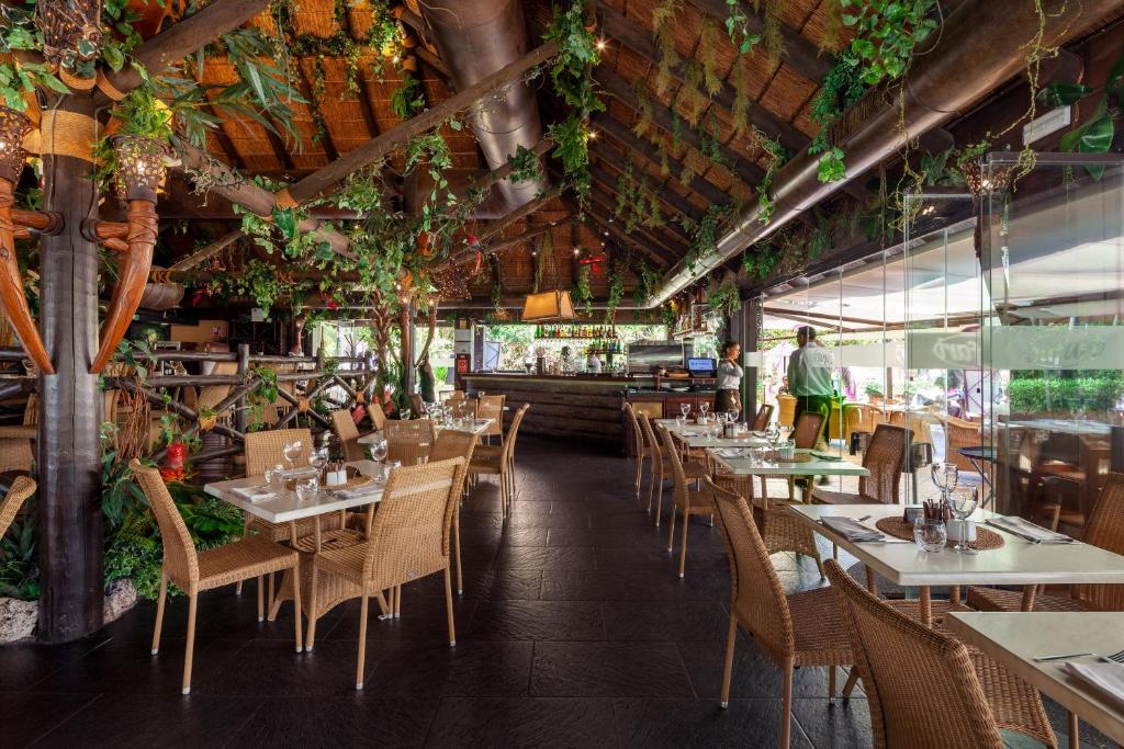 restauracja ze stołami, krzesłami i roślinami w obiekcie Garden & Sea Apartments Mijas Costa & Fuengirola w mieście Mijas Costa