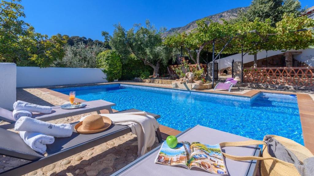 una piscina con mesa y sillas junto a una casa en Alojamiento Rural El Aguelo Belmez de la Moraleda by Ruralidays, en Jaén