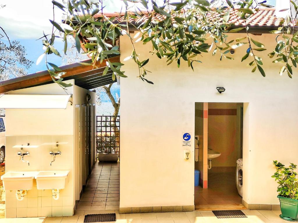 ein Badezimmer in einem Haus mit einem Baum in der Unterkunft Camping Baldo in Brenzone sul Garda