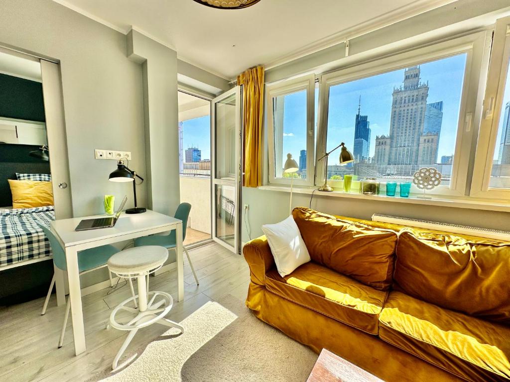 a living room with a couch and a desk and a window at GOLD 2 King Size Bed, metro x2 free WiFi, 50'TV Netflix, HBO, AppleTV+ in Warsaw
