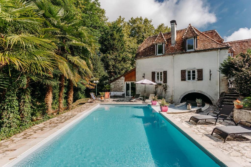 uma piscina em frente a uma casa em Le moulin des Sens - SPA-SAUNA em Orthez