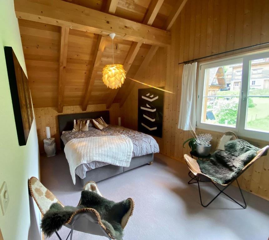 a bedroom with a bed and two chairs at Doppelzimmer in charmantem B&B in Hemberg