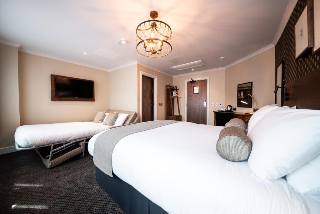 a hotel room with two beds and a chandelier at Miller & Carter Sheffield by Innkeeper's Collection in Sheffield