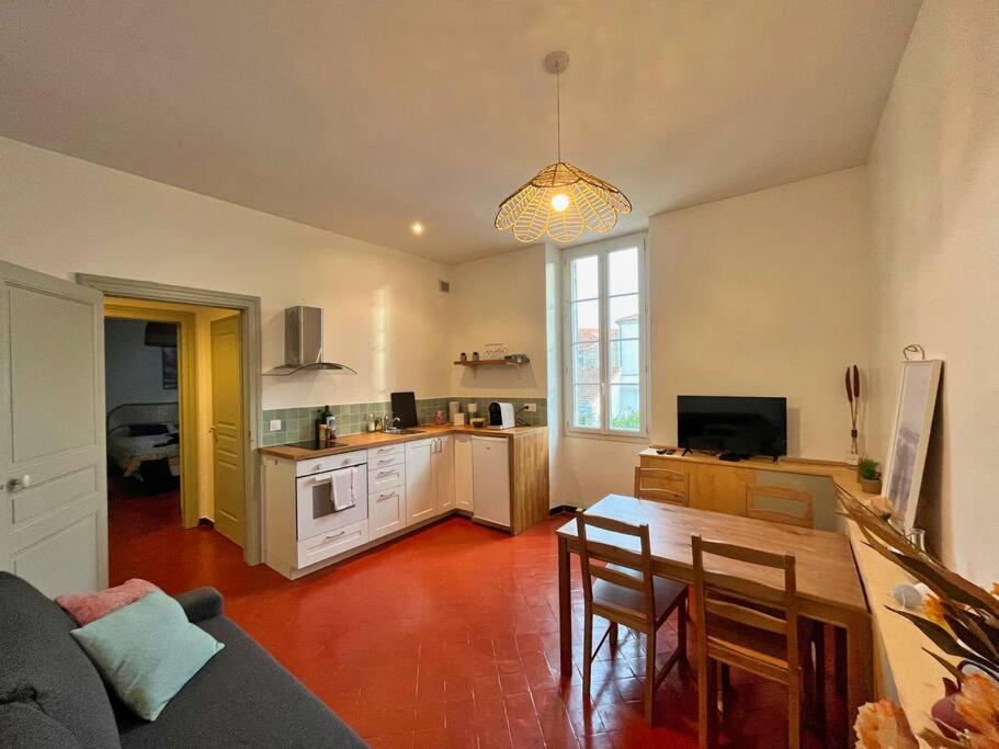 un salon avec une table et une cuisine dans l'établissement Clemence - Charmant T2 Calme et Lumineux, à Châteaurenard