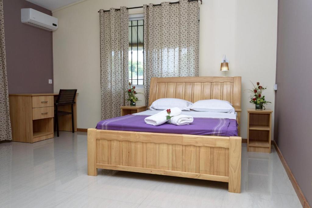 um quarto com uma cama com toalhas em Vintage Lodge em Quatre Bornes