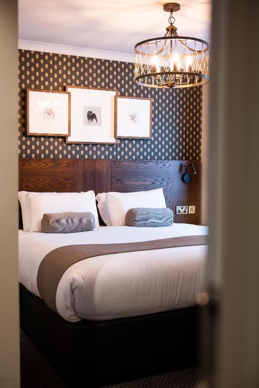 a bedroom with a large bed and a chandelier at Miller & Carter Sheffield by Innkeeper's Collection in Sheffield