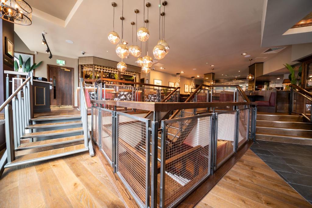 a restaurant with stairs and a bar with chandeliers at Miller & Carter Sheffield by Innkeeper's Collection in Sheffield