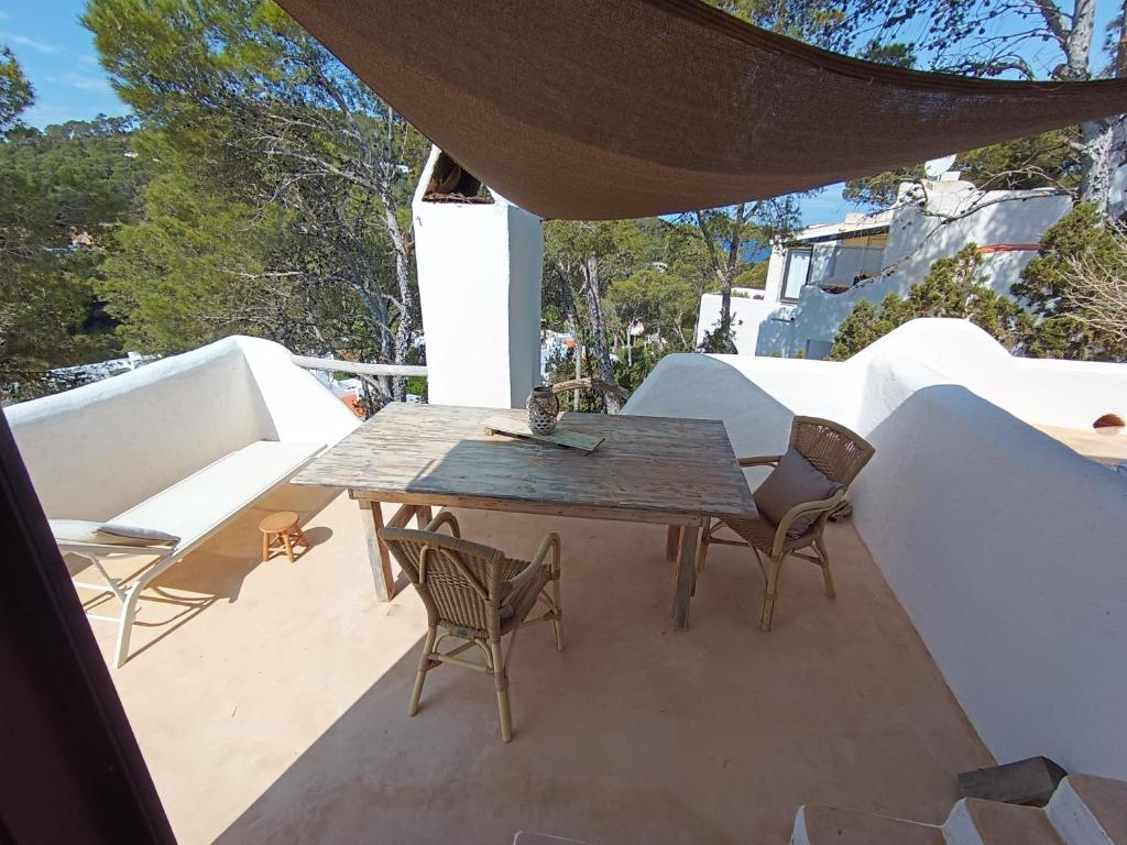 a wooden table and chairs on a patio at wonderful sunsets views from terraces Last minute in Cala Vadella