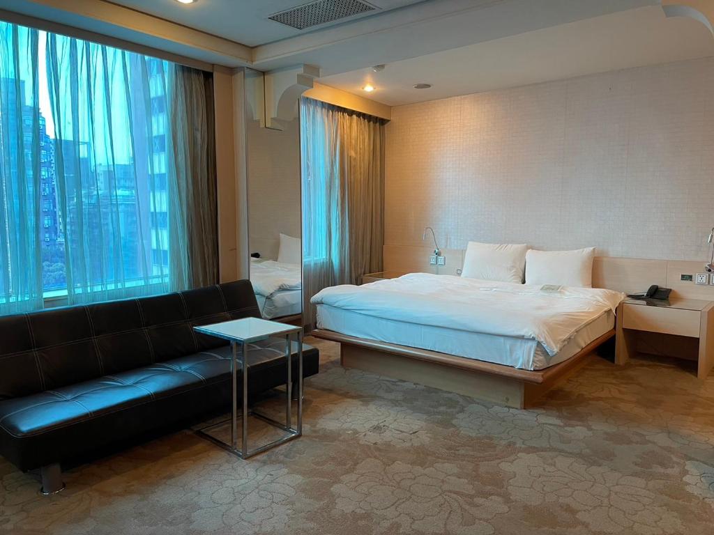 a hotel room with a bed and a couch at Yomi Hotel - ShuangLian MRT in Taipei