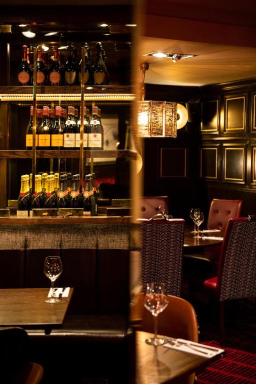 a restaurant with two tables and a bar with wine glasses at Miller & Carter Sheffield by Innkeeper's Collection in Sheffield