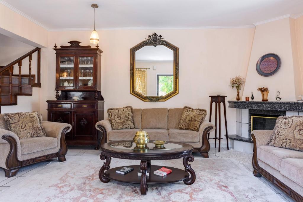 uma sala de estar com um sofá e uma mesa em Villa Armeni by CorfuEscapes em Corfu Town
