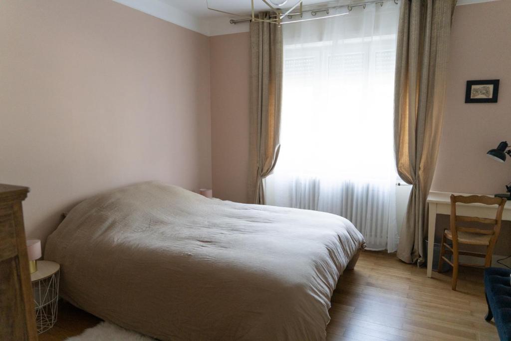 a bedroom with a bed and a large window at Yapot in Colmar