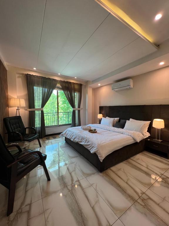 a large bedroom with a large bed and a chair at Ortus - Murree Hills in Murree