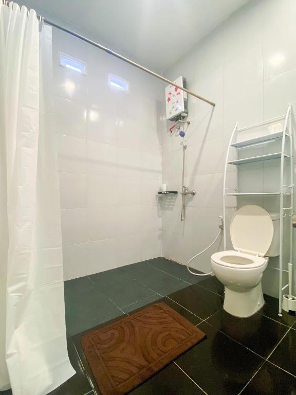 a bathroom with a toilet and a shower stall at Snooze Malang in Malang