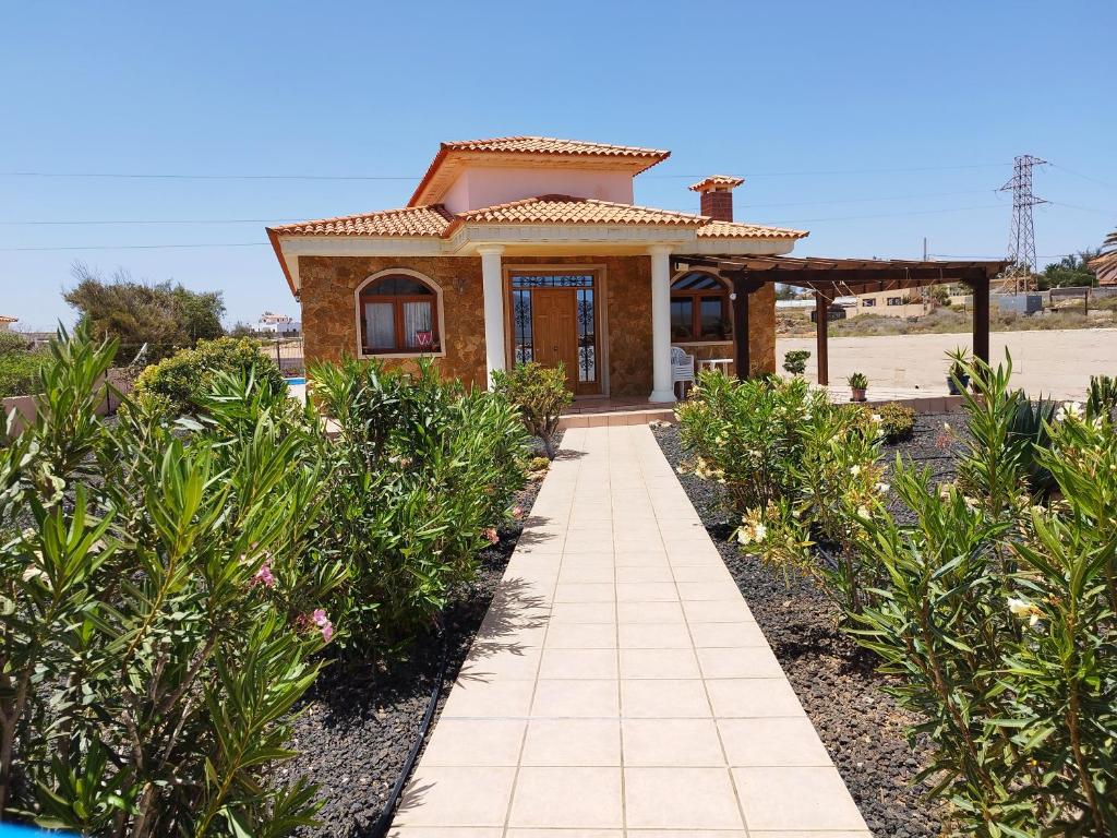 a small house with a pathway in front of it at Villa Casa Del Sol 3 Bedroom Villa With Private Solar Covered 12m x 6m Pool Minimum Stay 7 Nights Chromecast And WiFi Throughout The Property in Triquivijate