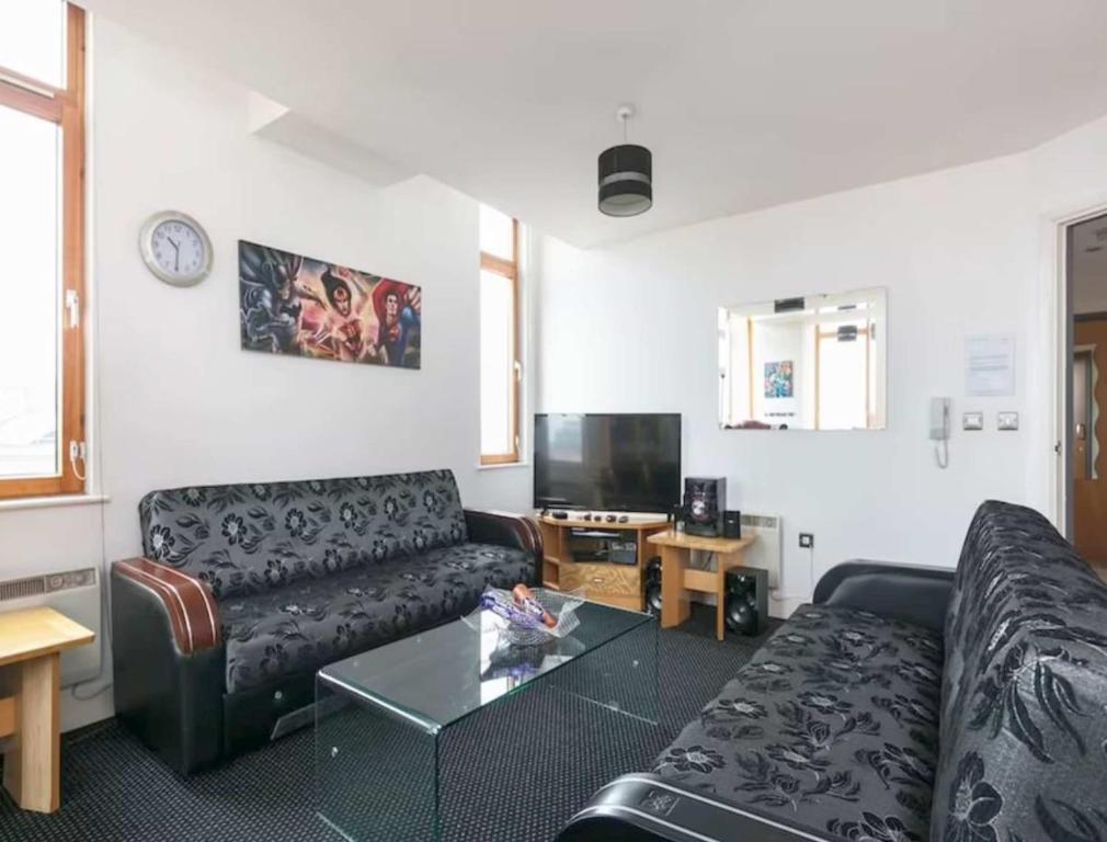 a living room with a couch and a table at City centre apartment with view in Manchester