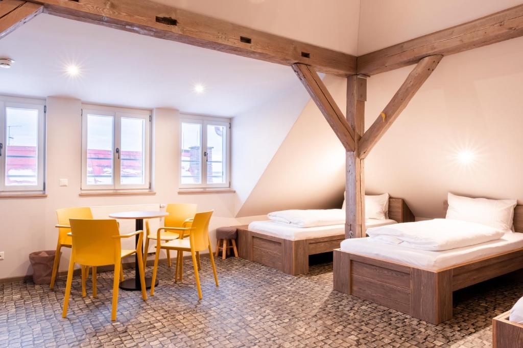 a room with two beds and a table and chairs at Kloster Bonlanden in Berkheim