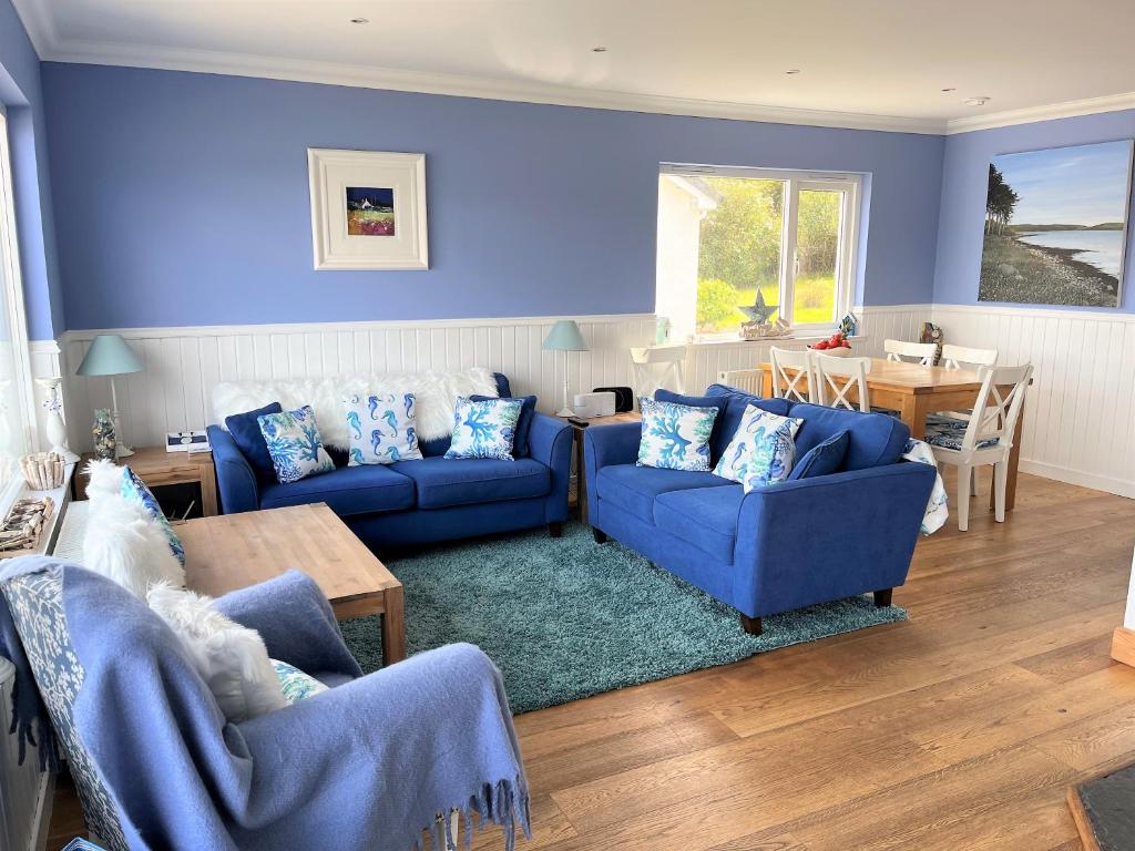 a blue living room with two blue couches and a table at Craignethan in Kames