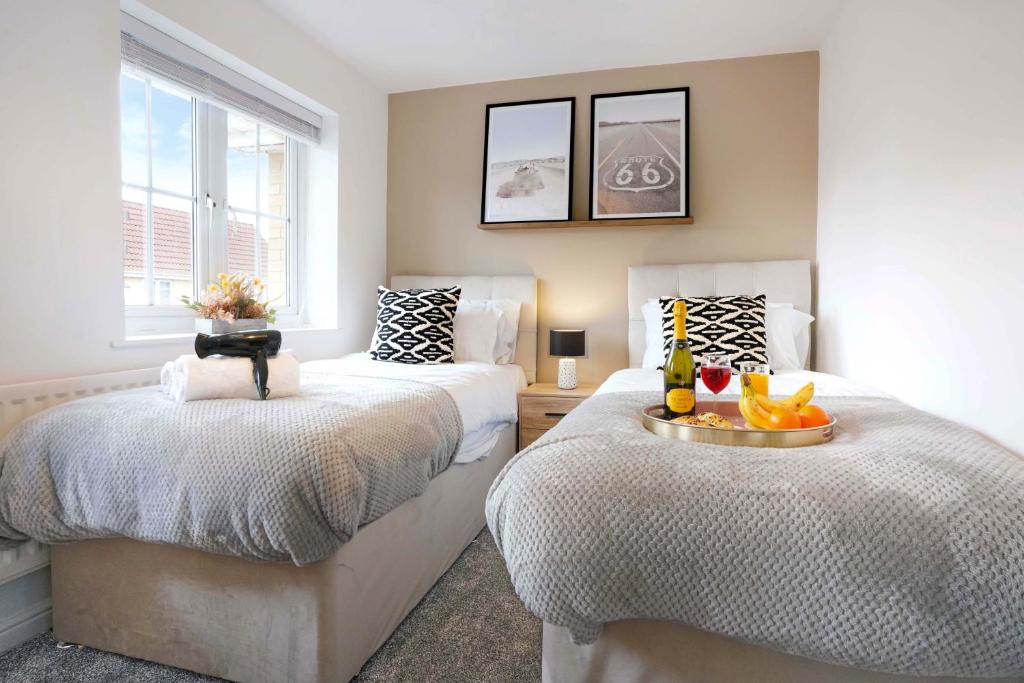 a bedroom with two beds and two windows at Stylish House - Close to City Centre and Luton Airport - Free Parking, Super-Fast Wifi, Garden and Smart TV with Netflix by Yoko Property in Luton