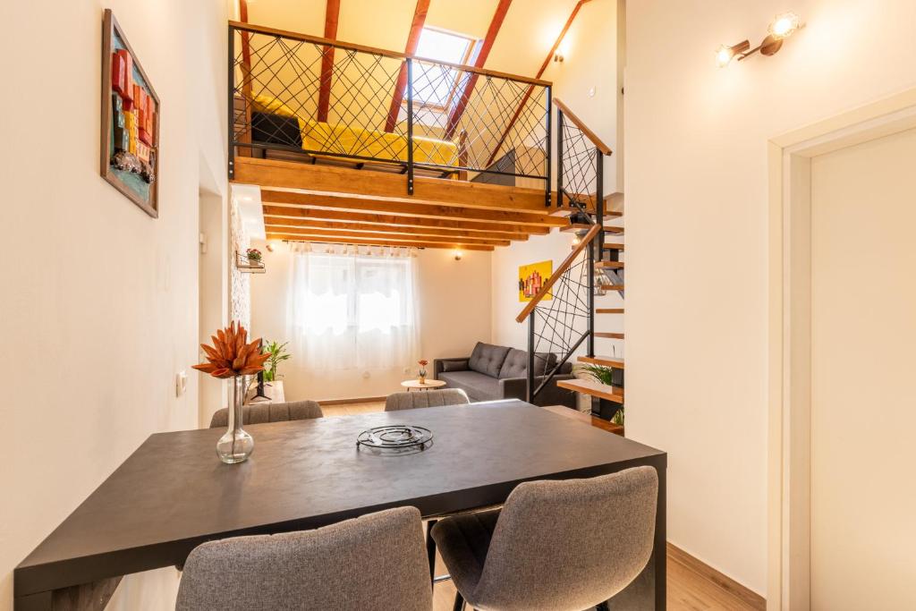 un comedor con mesa y sillas y una escalera en Apartment Gazic, en Zadar