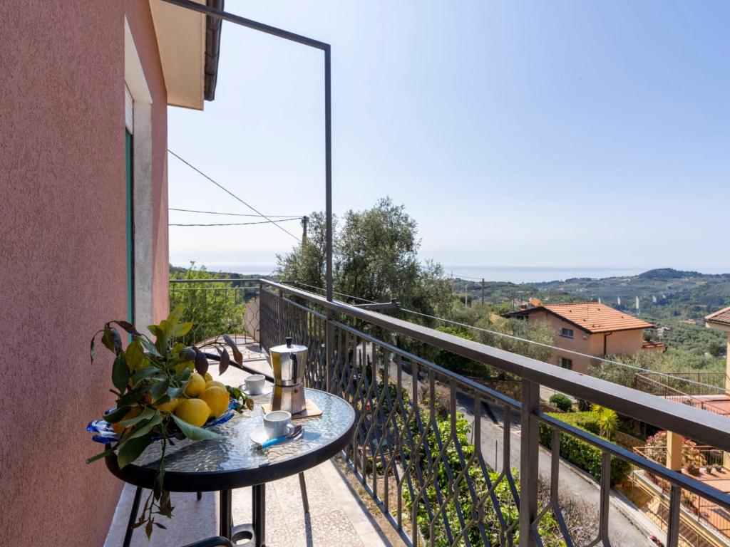 a table with a bowl of fruit on a balcony at Apartment Carleadri by Interhome in Civezza