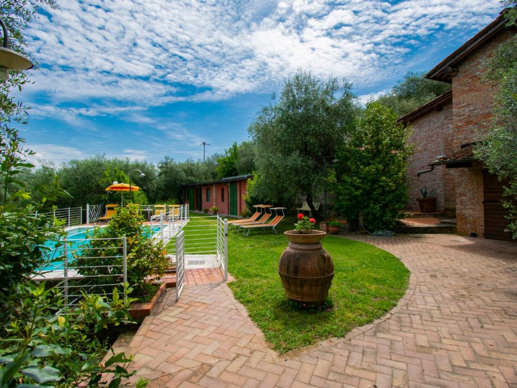 einen Hinterhof mit einem Pool und einer Vase im Gras in der Unterkunft Holiday Home Colle alla luna by Interhome in Pieve a Nievole