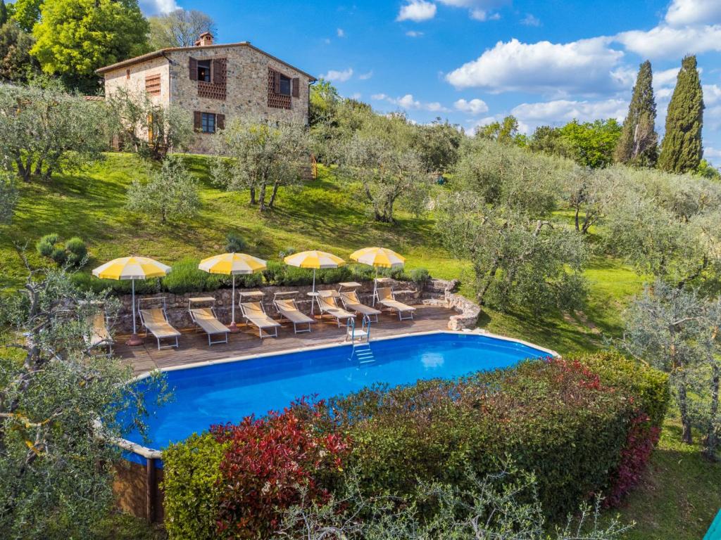 una vista esterna di una villa con piscina e ombrelloni di Holiday Home Poggio all'Aia by Interhome a Lucciana