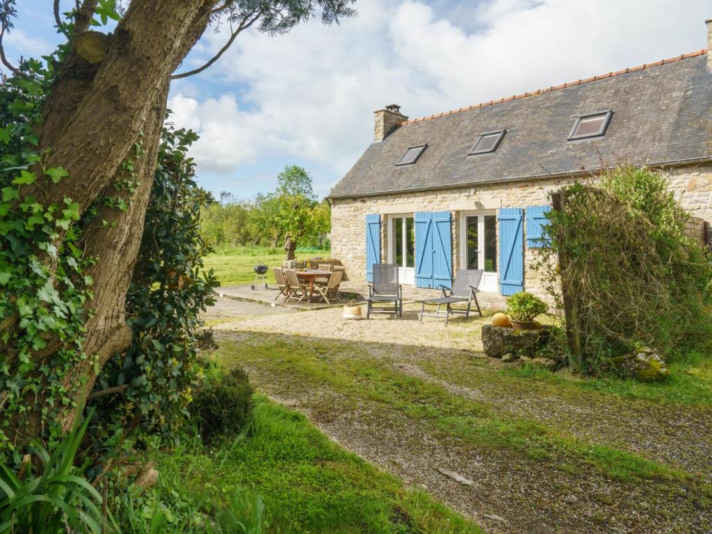 ein altes Cottage aus Stein mit blauen Türen und einem Picknicktisch in der Unterkunft Holiday Home Pen Ilis by Interhome in Saint-Jean-Trolimon