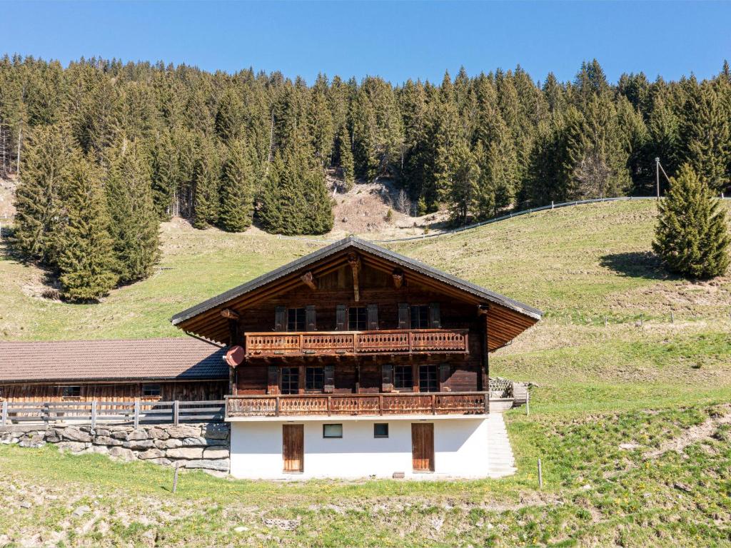 a building on a hill with trees in the background at Chalet Naulaz by Interhome in Val-d'Illiez