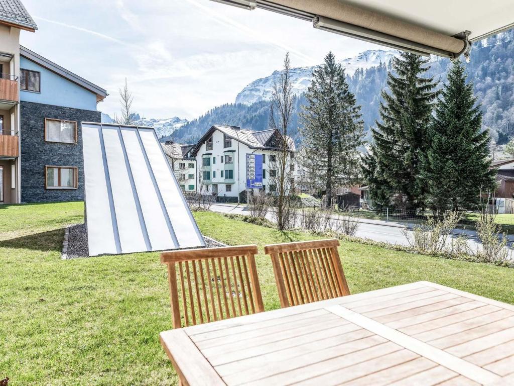 einen Tisch und Stühle auf einer Wiese mit Aussicht in der Unterkunft Apartment TITLIS Resort 3-Zimmer Familienwohnung 2 by Interhome in Engelberg