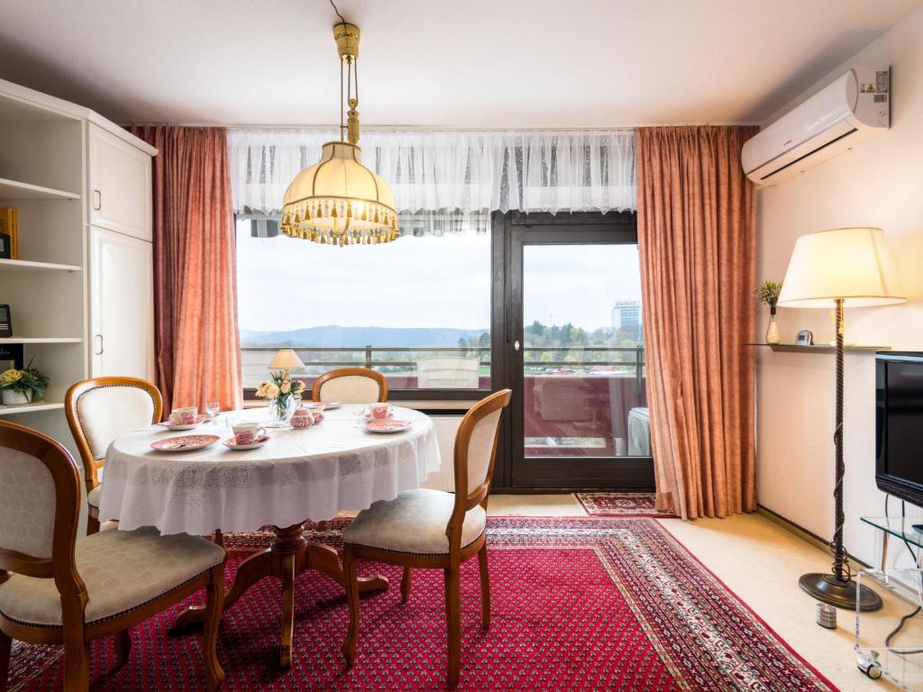 d'une salle à manger avec une table, des chaises et une fenêtre. dans l'établissement Apartment A905 by Interhome, à Lahnstein