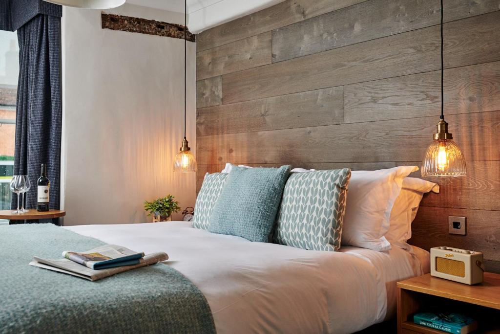 a bedroom with a large bed with a wooden wall at The Red Lion in Odiham