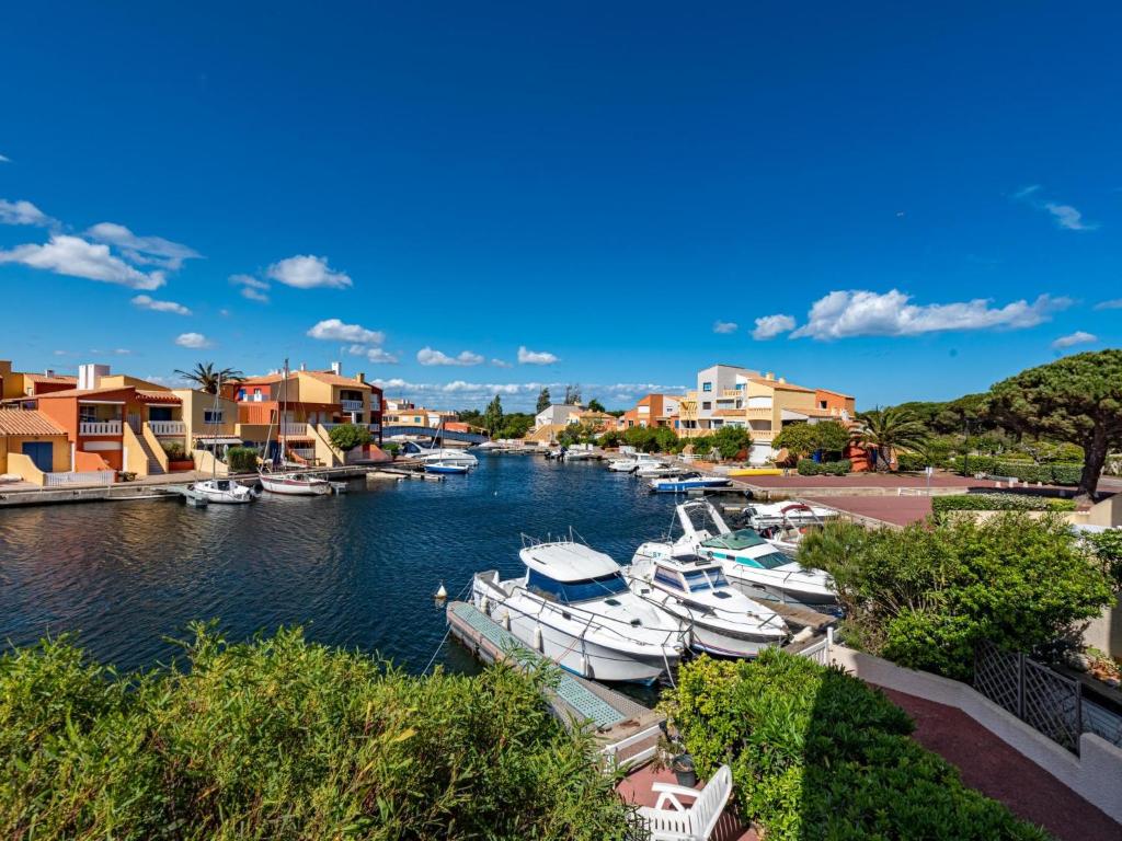 a group of boats docked in a river with houses at Holiday Home Nautica-3 by Interhome in Le Barcarès